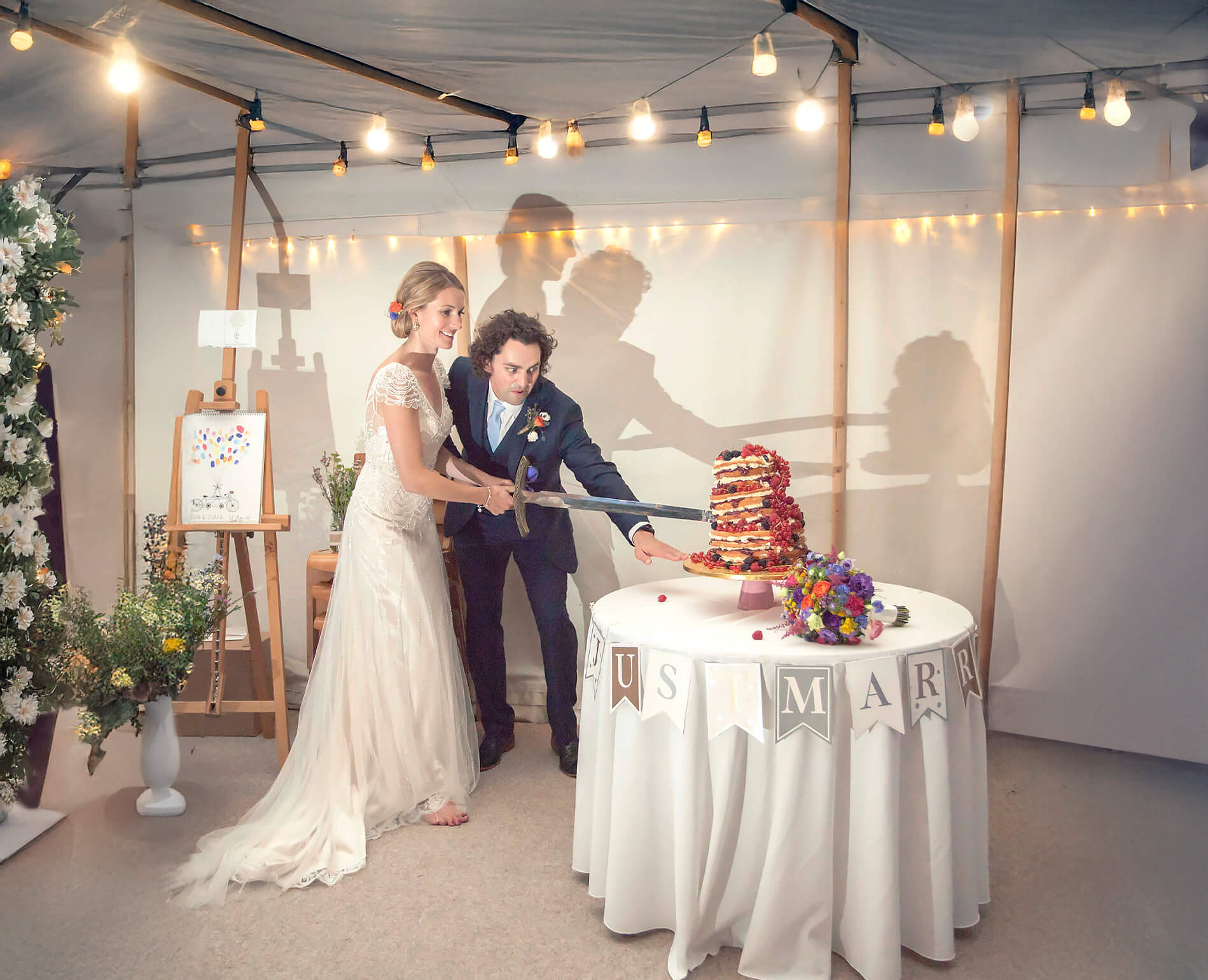 Newly weds cut wonky wedding cake with a Celtic sword.